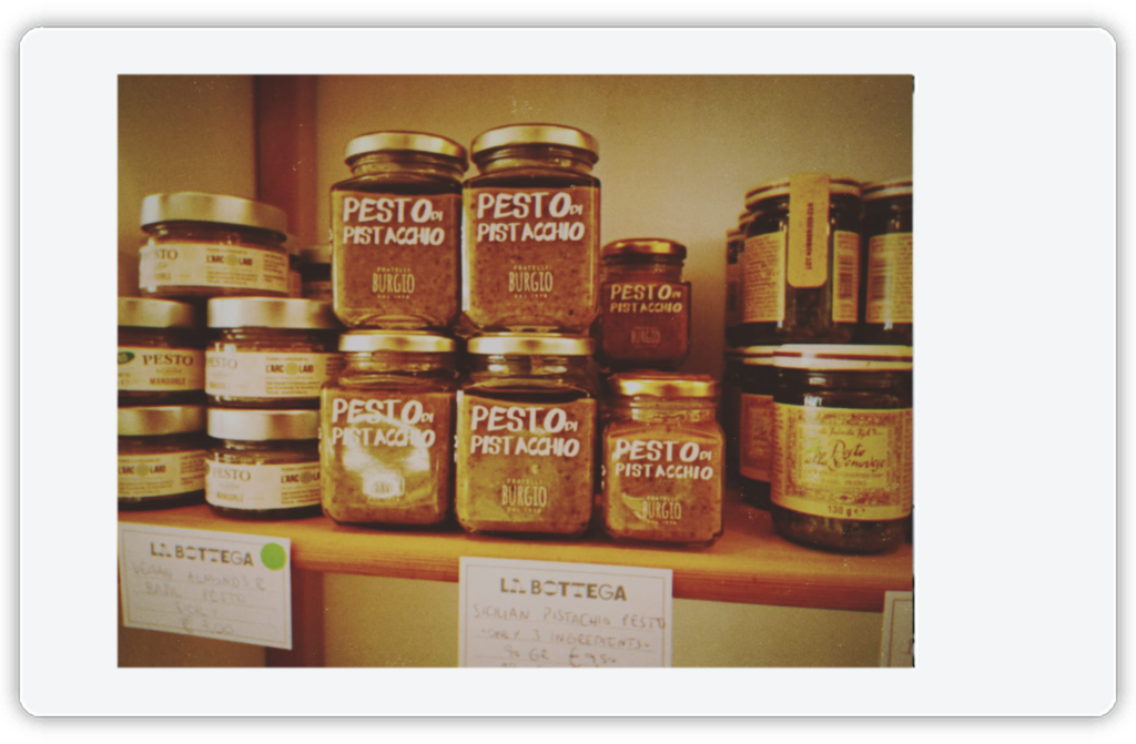 A photo of jars of pistachio pesto on the shelves of Chiara's Italian food store La Bottega.